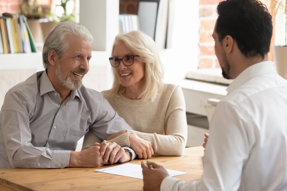 Smiling couple meets with their periodontist